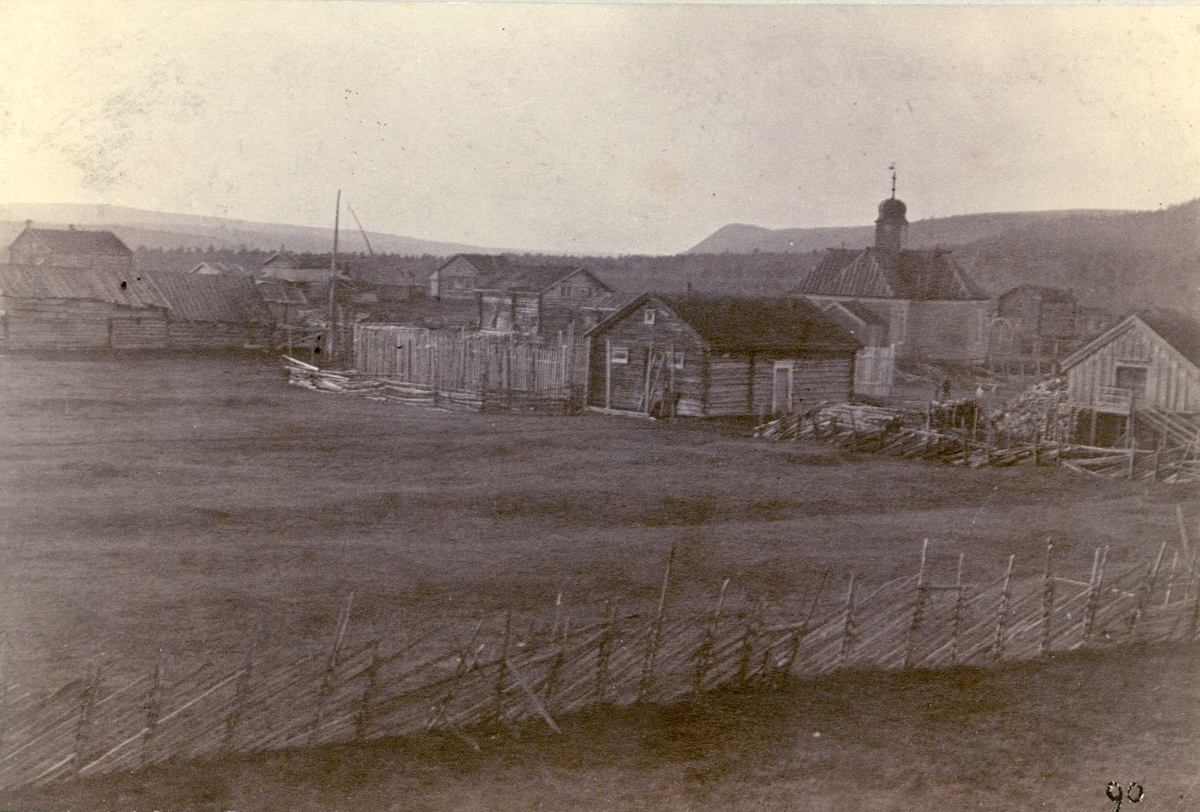 Karasjok, Finnmark. Fotografi fra tettsted med kirke, boliger, uthus og innhegninger.