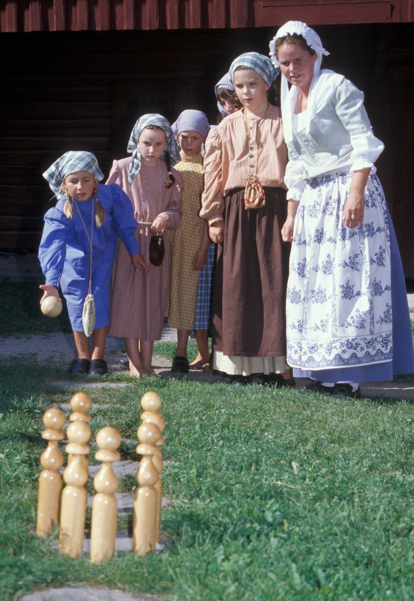 Levendegjøring på museum.
Elever ved Ferieskolen august 2004. De spiller et kjeglespill sammen med tjenestejenta i Chrystiegården. 
Norsk Folkemuseum, Bygdøy.