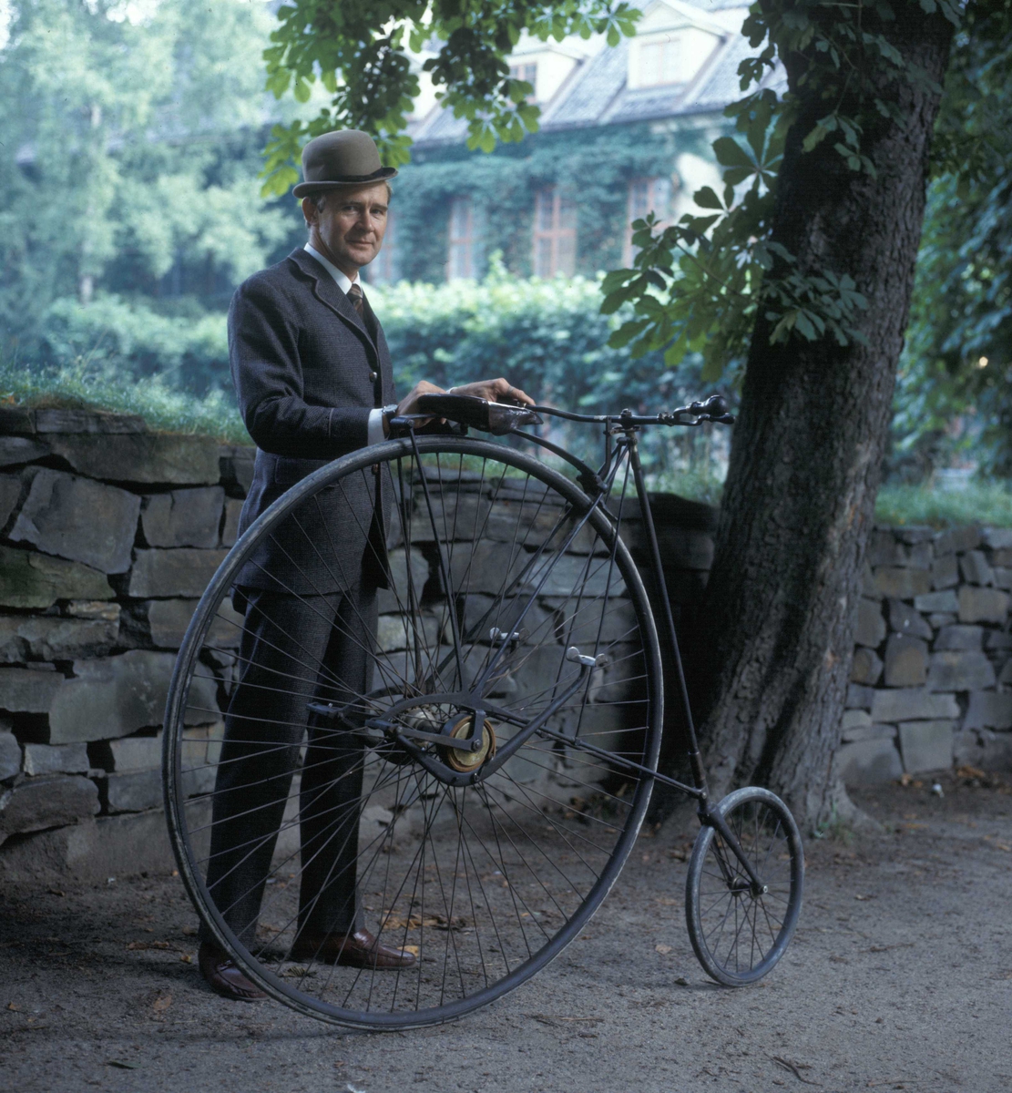 Høstmarked 1985. Einar Tveit i kostyme med en gammel sykkel av typen velociped, også kalt veltepetter på folkemunne.