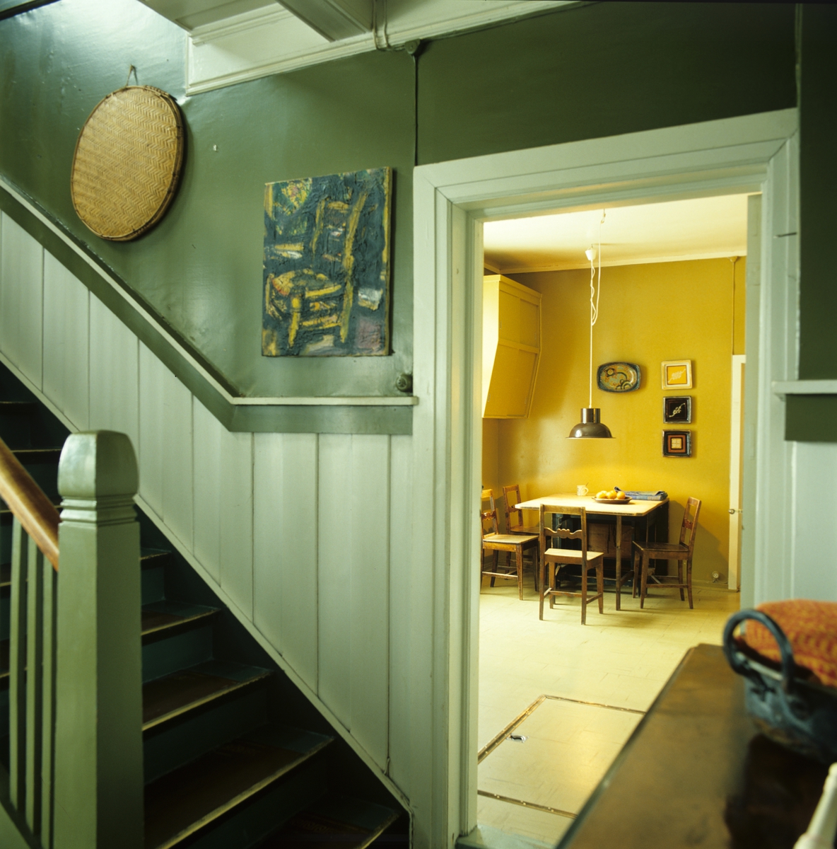 Trapp til annen etasje i hus fra ca. 1860 i Nes på Romerike. Dør inn til kjøkken med spiseplass. Fotografert for Bonytt 1983.