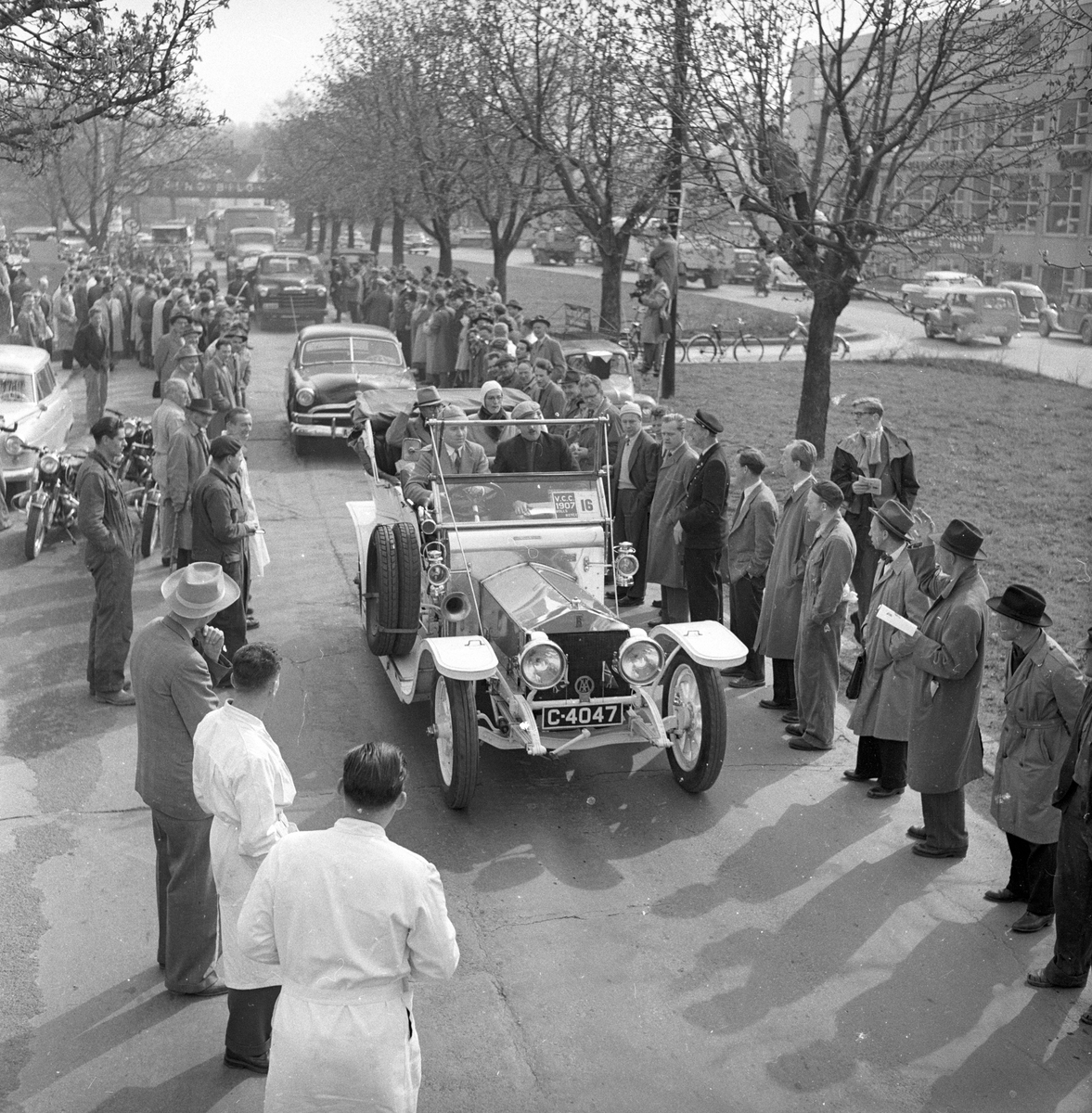 Veteranvogn Rally Oslofjord 1951. Sjåfør og passasjer kjører veteranbil. Publikum langs traseen. Fotografert ant. 1951.