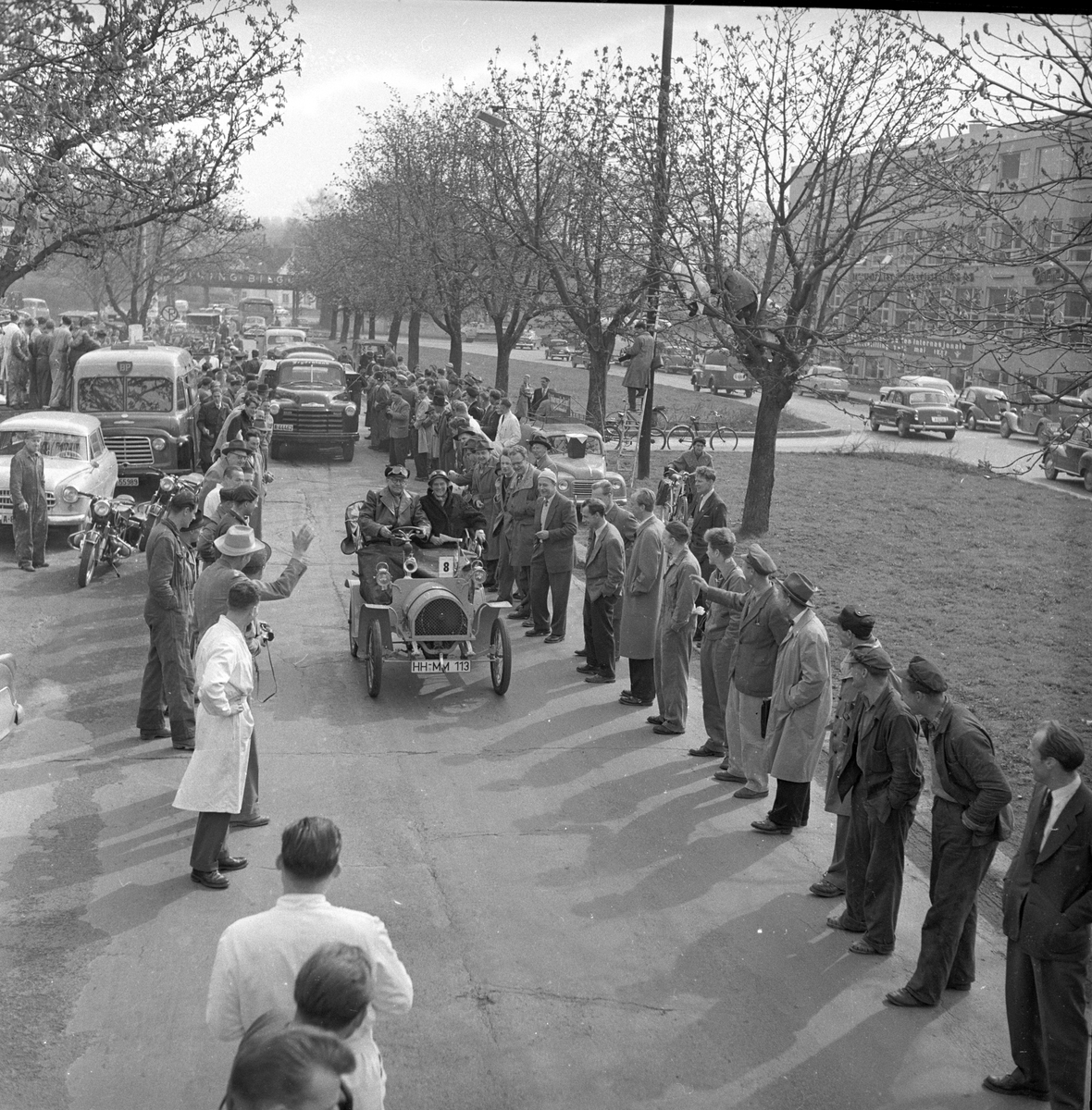 Veteranvogn Rally Oslofjord 1951. Sjåfør og passasjer kjører veteranbil. Publikum langs traseen. Fotografert ant. 1951.