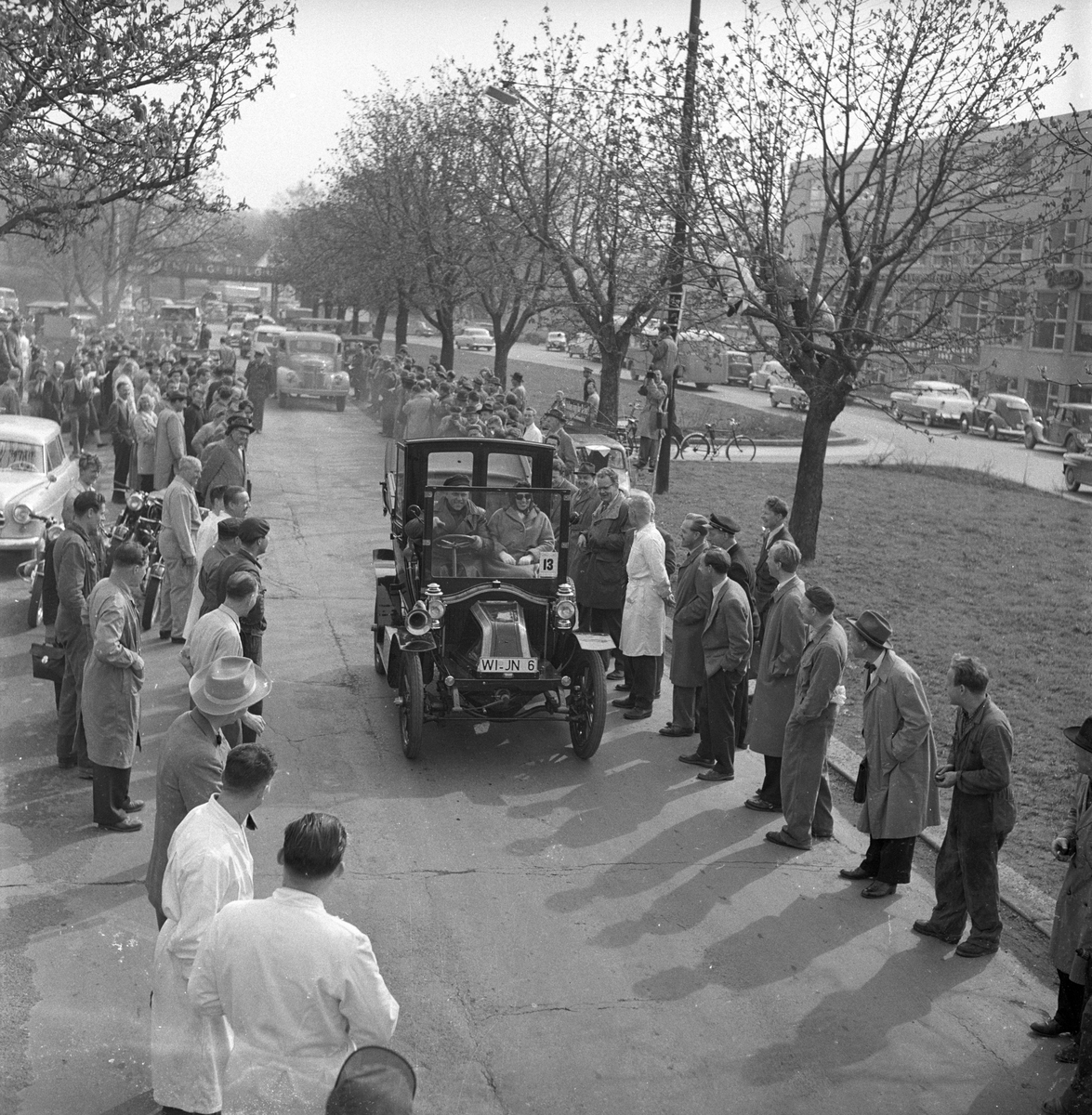 Veteranvogn Rally Oslofjord 1951. Sjåfør og passasjer kjører veteranbil. Publikum langs traseen. Fotografert ant. 1951.