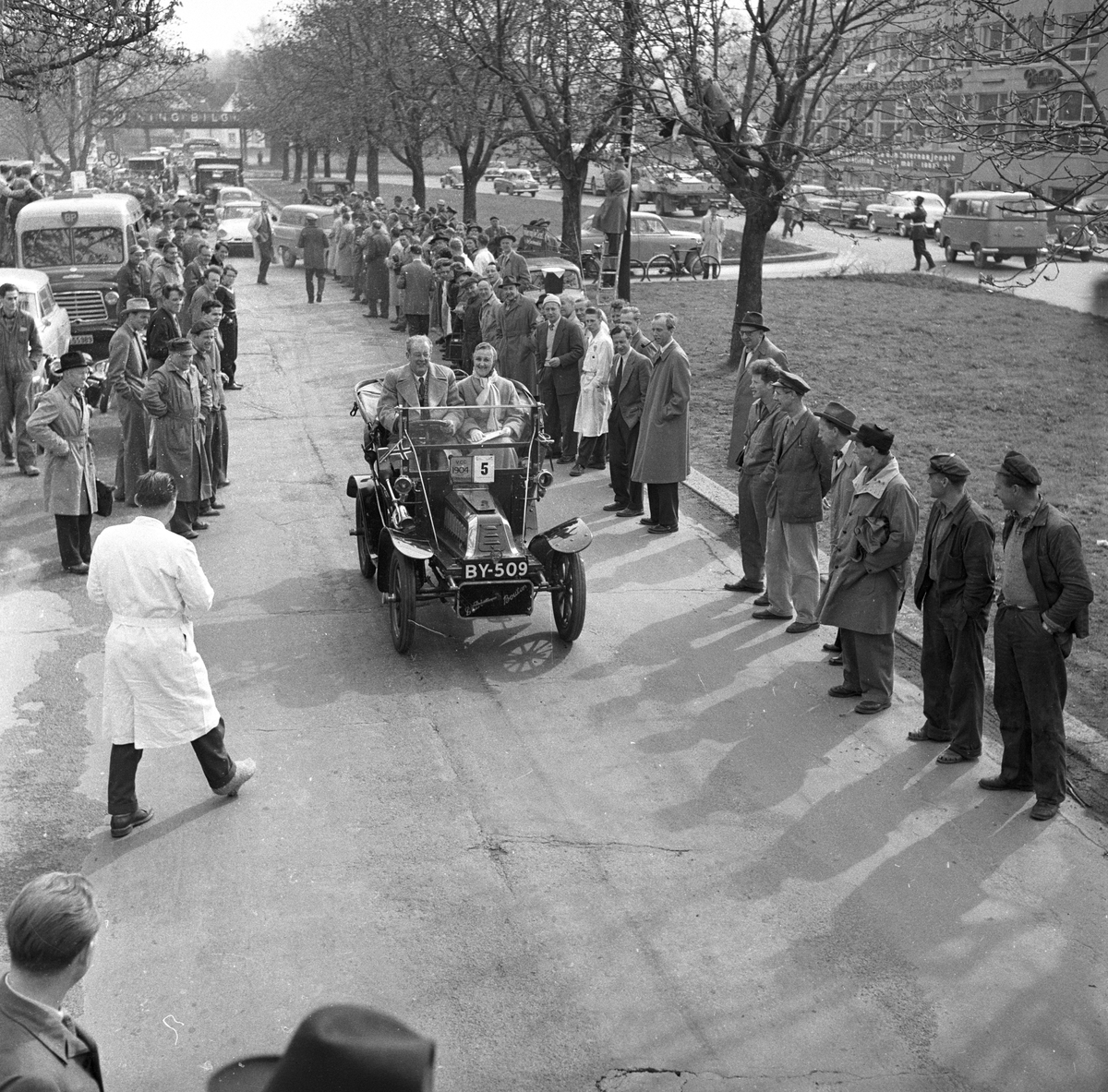 Veteranvogn Rally Oslofjord 1951. Sjåfør og passasjer kjører veteranbil. Publikum langs traseen. Fotografert ant. 1951.