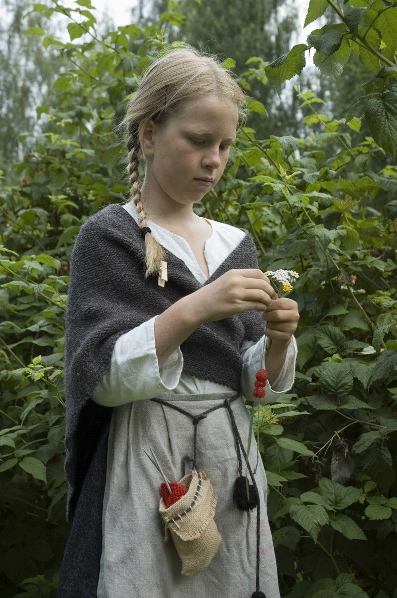 Levendegjøring på museum.
Ferieskolen uke 31 i 2006. En av elevene plukker bær og trer dem på strå. Norsk Folkemuseum, Bygdøy.