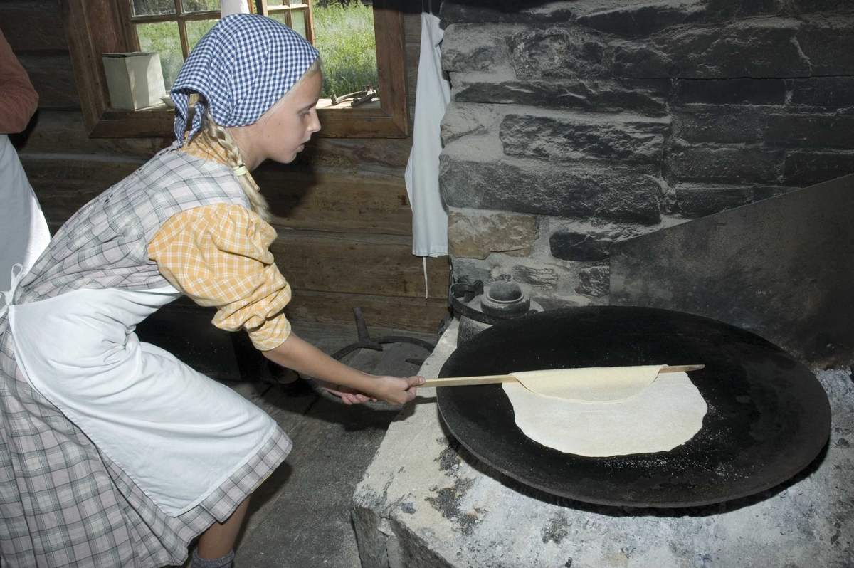 Levendegjøring på museum.
Ferieskolen uke 31. Baking av lefser i eldhuset fra Bakke, NF024.
Norsk Folkemuseum, Bygdøy.