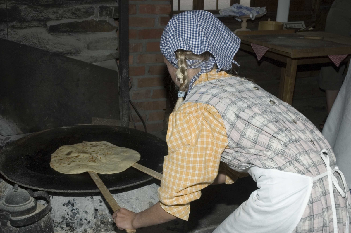 Levendegjøring på museum.
Ferieskolen uke 31. Baking av lefser i eldhuset fra Bakke, NF024.
Norsk Folkemuseum, Bygdøy.