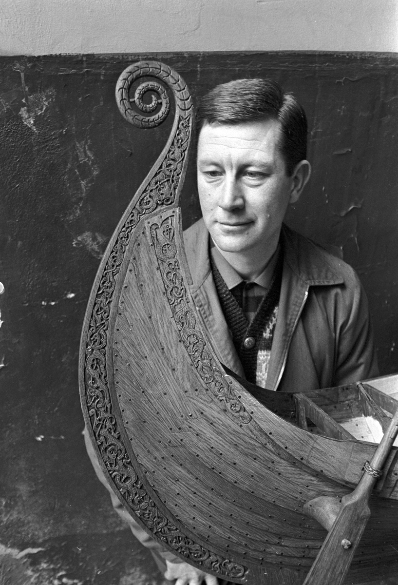 Serie. To menn bærer ut en modell av vikingeskipet "Osebergskipet" av en kjeller. Fotografert 1967.