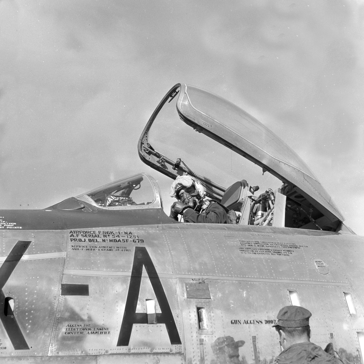 Serie. Mange uniformskledde personer er samlet i anledningen at et jagerfly skal bryte lydmuren. Jagerpiloten sitter i flyet. Fotografert 12. og 13. september 1955.