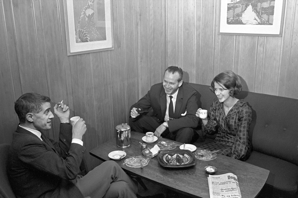 Serie. Ombord på SAS flyet til Tromsø. Flyfoto over snødekkete fjell. To flyvere i flytårnet. To menn og en kvinne, ant. Eva Lie, sitter rundt et bord. Fotografert desember 1965. 