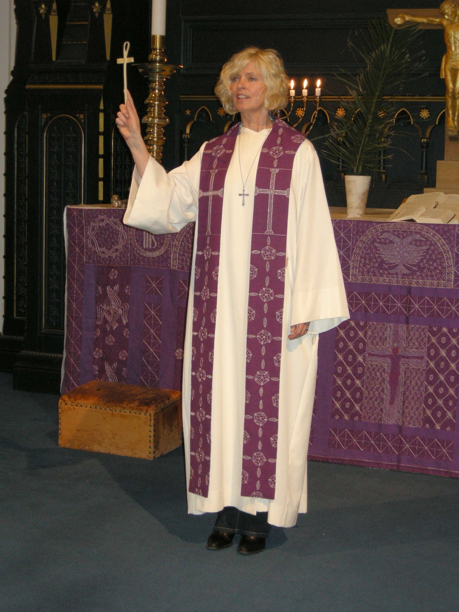 Domkirken i Kristiansand. Palmesøndag, 16.03.2008. Velsigning av palmekors. Serie bilder med kapellan Birte Løvåsen kledd i hvit alba og lilla stola ved koret i kirken. Palmeblader. Kors. Kirketekstilene er utført av Borgny Farstad Svalastog.  