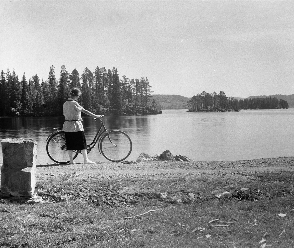 Dordi Arentz med sykkel står ved Jonsvannet juni 1925.