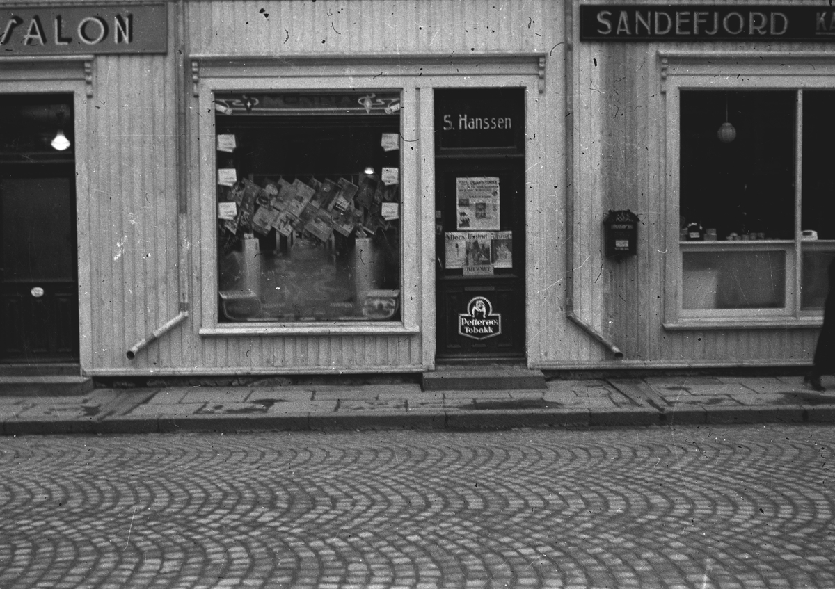 Gatebilde av S. Hanssen kiosk med reklame for Petterøes Tobak på døren.