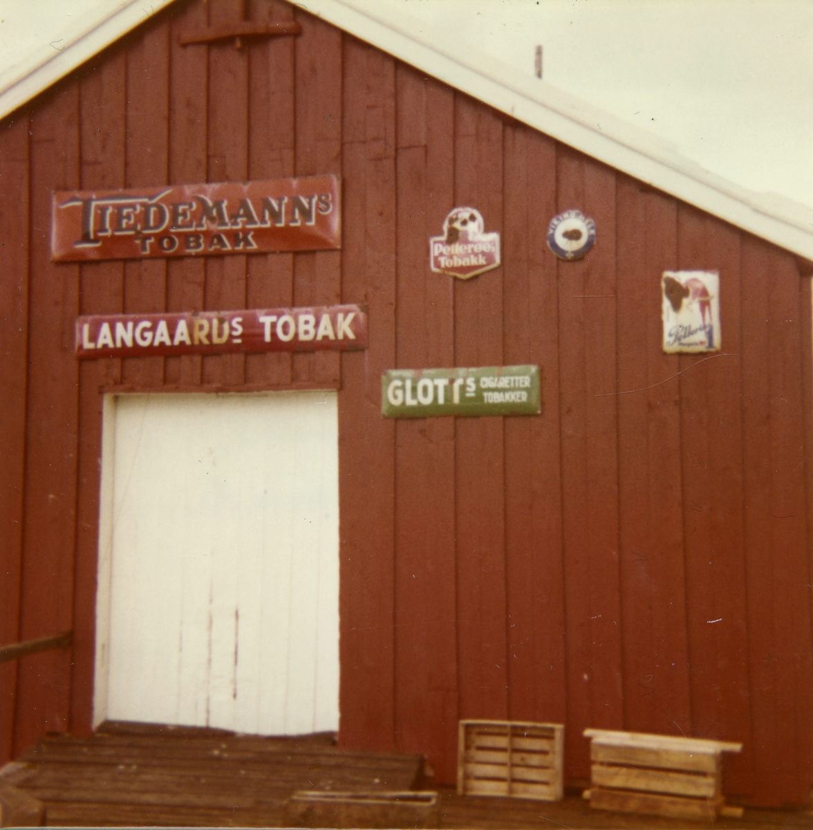 Bygning på Nordbynes i Malangen. Skilt med reklame for tobakk på veggen.