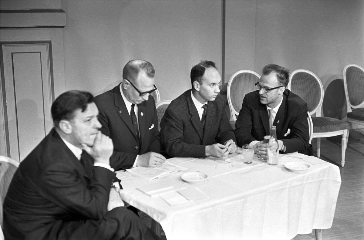 Alvorlige herrer ved bord under TV-debatt om idrett i Centralteatret i november 1965.
