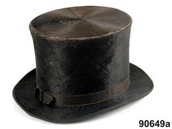 Dräkt. Hel mansdräkt från Österåker A.-F.

A. Hatt
B.Långrock
C.Knäbyxor
D.
E
F. Halsduk

A. Hatt, höjd 15 cm, cylinderformig av svart felb, brättet uppvikt vid sidorna och kantat med svart sidenband....