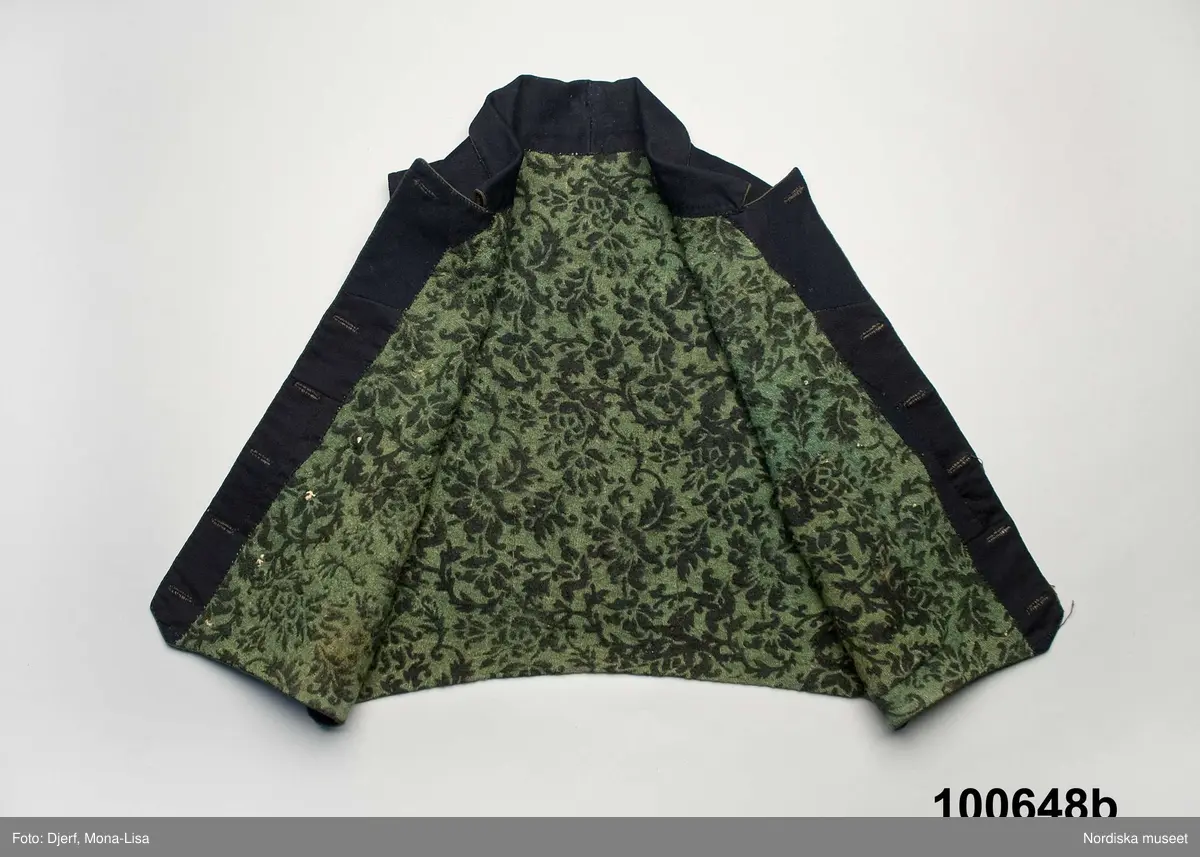 Huvudliggaren (år 1904-1905):
"100.648 a-c Brudgumsdräkt (1830-talet). Tröja, väst och byxor. Av mörkblått kläde. Tröjan och västen fodrade med ylle i grönt och svart, tryckt mönster, byxorna med 'smaik' lucka. Skåne Albo hd Andra-rums sn. Ink. 1904 2/9 Reimer P. L., skollärare, Järstorp, Lövestad. 10:- Bil. Reimer 9"