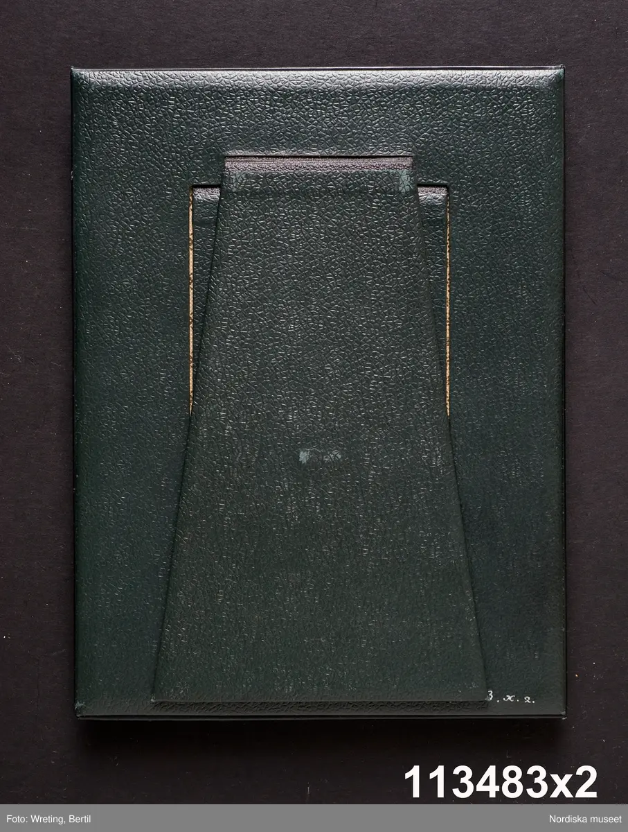 Huvudliggaren:
"a-å
Skrivbordsuppsats, 25 olika pjäser, däribland lampa, ljusstake m.m. allt ornerat med frimärksklipp. Jämte 4 mindre lådor med lösa frimärksdelar. Gåva 17/5 1909 av fru Augusta Cronholm f. Bratt, Birgerjarlsgatan 18, Stockholm."