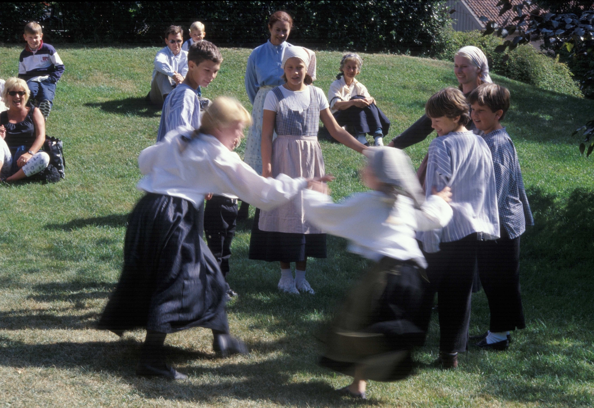 Fra åpningen av den historiske lekeplassen den 16. august 1999.Barn i drakter danser mens publikum følger med.