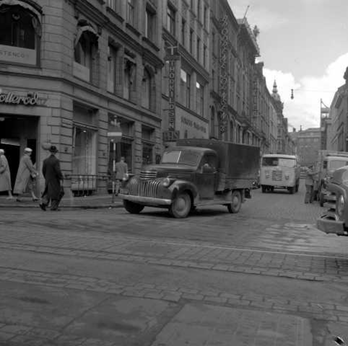 Trafikkbilde fra Oslo i 1956. Lastebil av typen Chevrolet 1946-47 pickup runder hjørnet. Til høyre skimtes grillen på en Opel Blitz 1952-60.