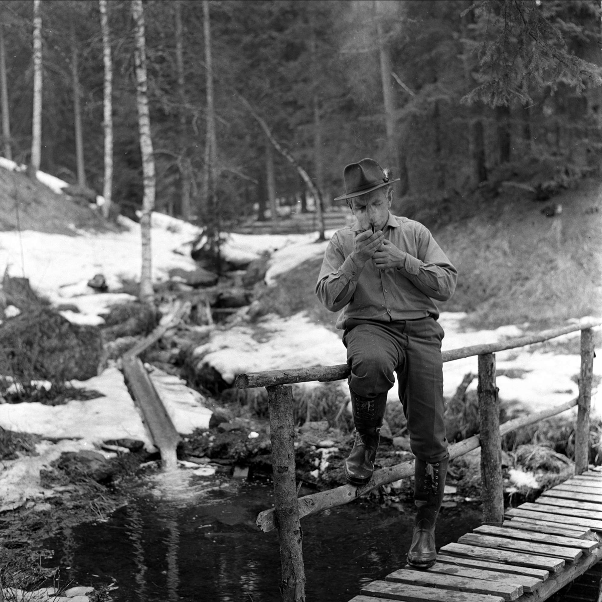 Mann på bru i skogen, april 1963.