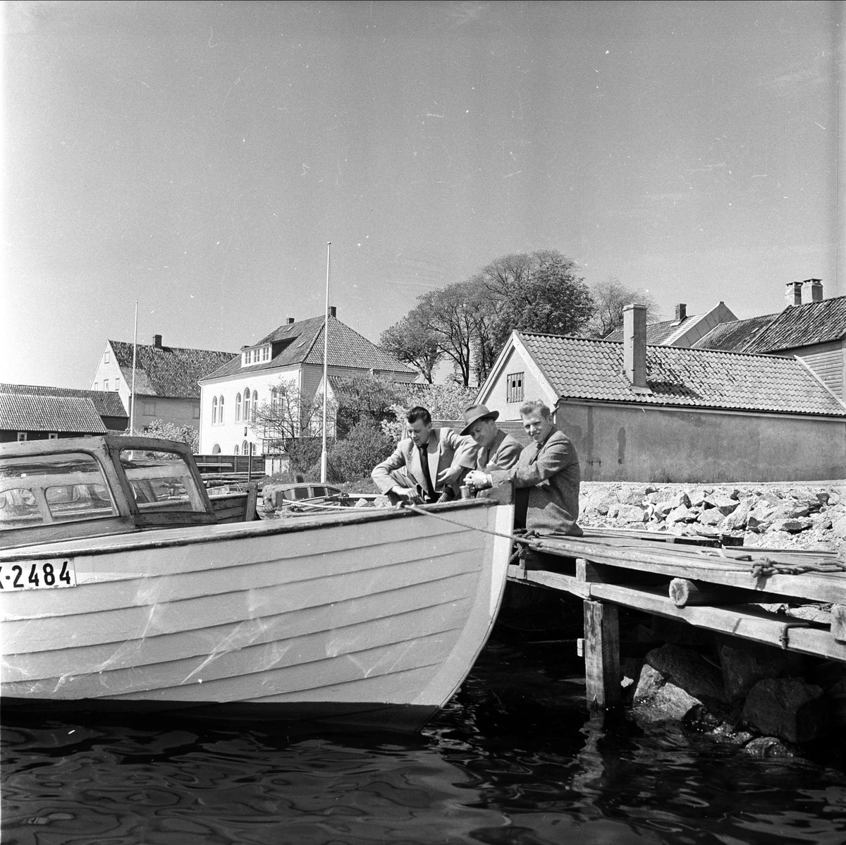 Sørlandet, mai 1955. Bebyggelse og snekke ved brygge.