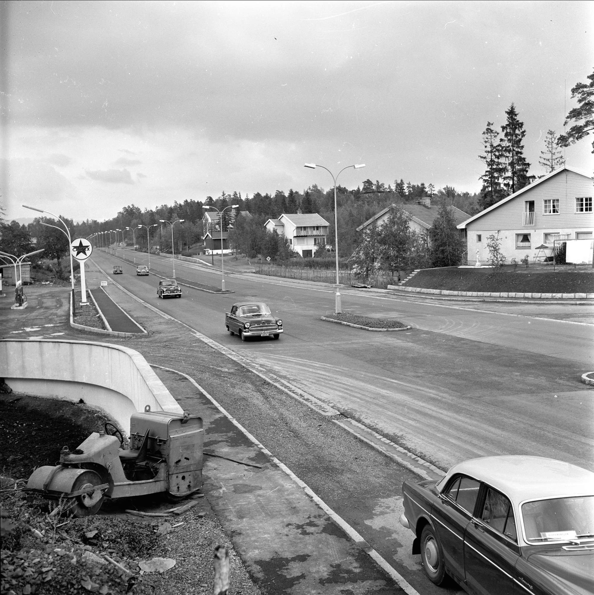 Drammensveien ved avkjøringen til Fornebu, antakelig, 12.07.1959. Boliger, trafikk og dampveivals.