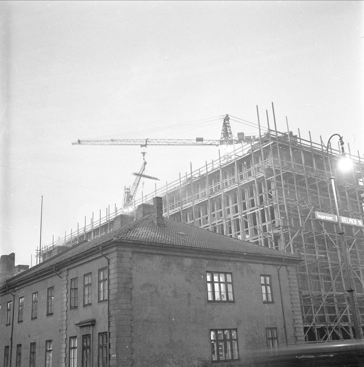 Akersgata i Oslo med det som var Justisdepartementet. Fotografert i 1957 med Regjeringsbygget under oppføring bak.