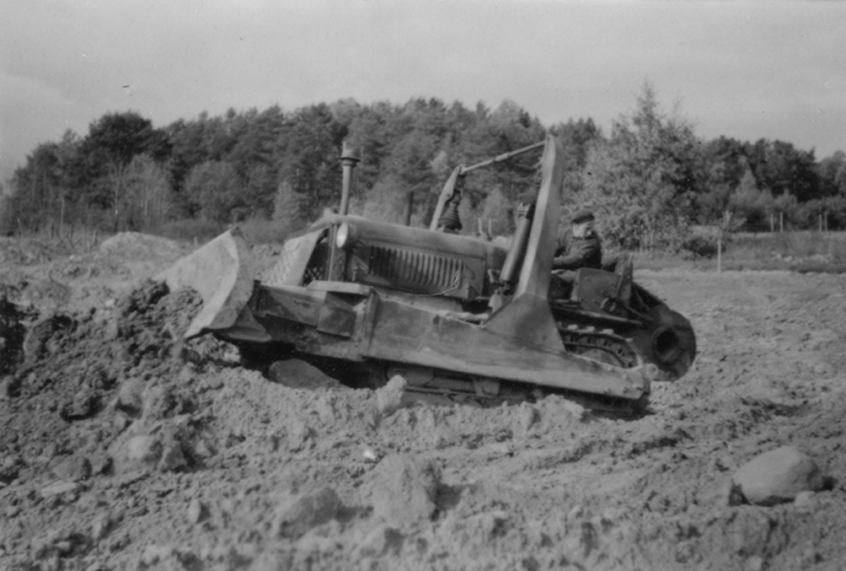 Idrottsplatsen på F 2 Roslagens flygflottilj byggs, 1943. Civilanställda tjänstemän i arbete med grävning. Människor och maskiner i arbete med grävning.