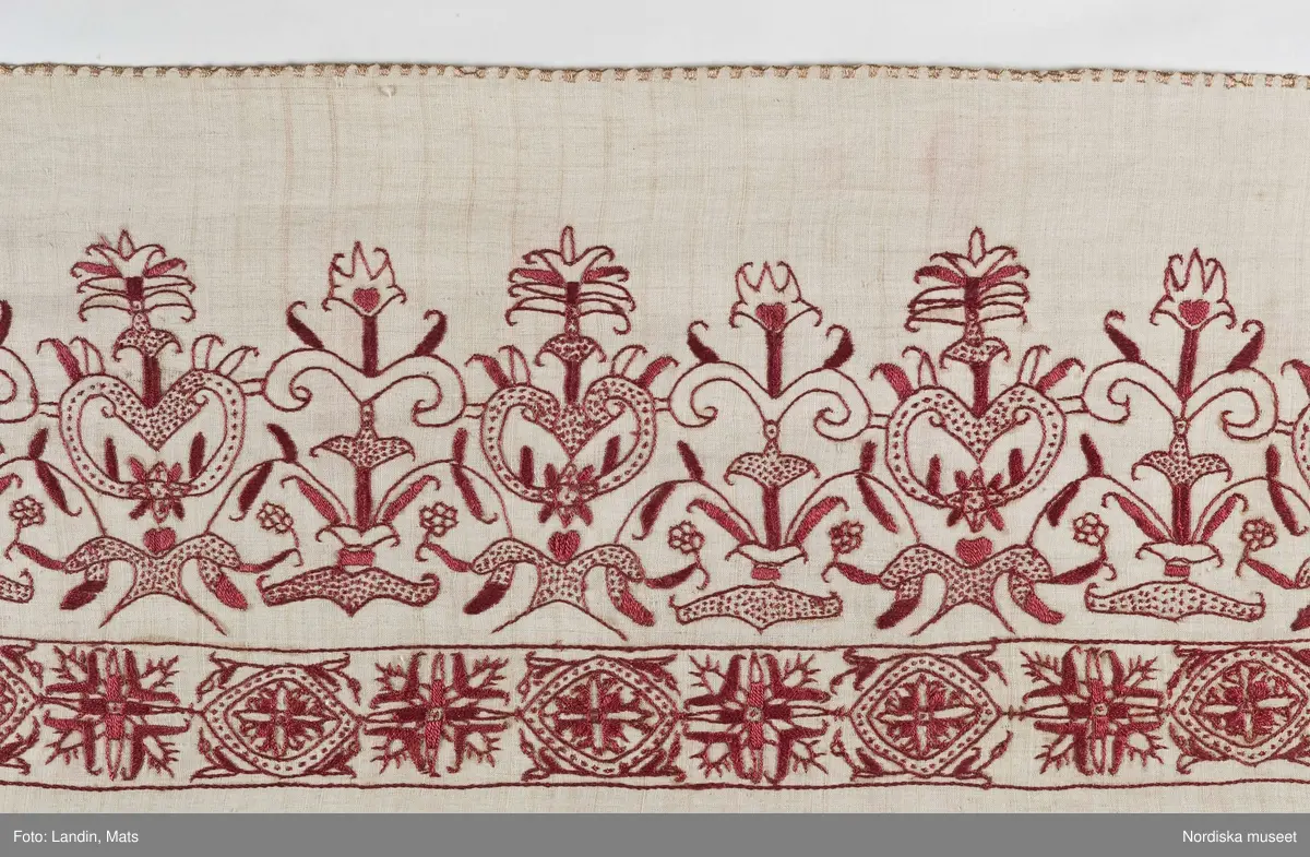 a. komplett lakan med broderad bård.
b. lakan samt lös bård i samma mönster

Mycket fint och tunt tuskaftat linne, broderad bård med stramt stiliserade blommor i renässansstil sydda med mörkt rött tvinnat silke, konturer i stjälksöm med vissa blad fyllda med plattsöm andra med prickar med små stygn. I kanten langetterad bård i gult silke med langettstygnen i grupper så att bården ser rutig ut. Ovanför bården märkt med adliga vapnen för ätten Stake och Posse samt initialerna ES och IP = Erik Olofsson Stake död 1598 gift 1588 med Ingeborg Posse.

Lös bård som hör till lakan b. Samma broderi som på lakan a.
/Berit Eldvik 2008-03-04