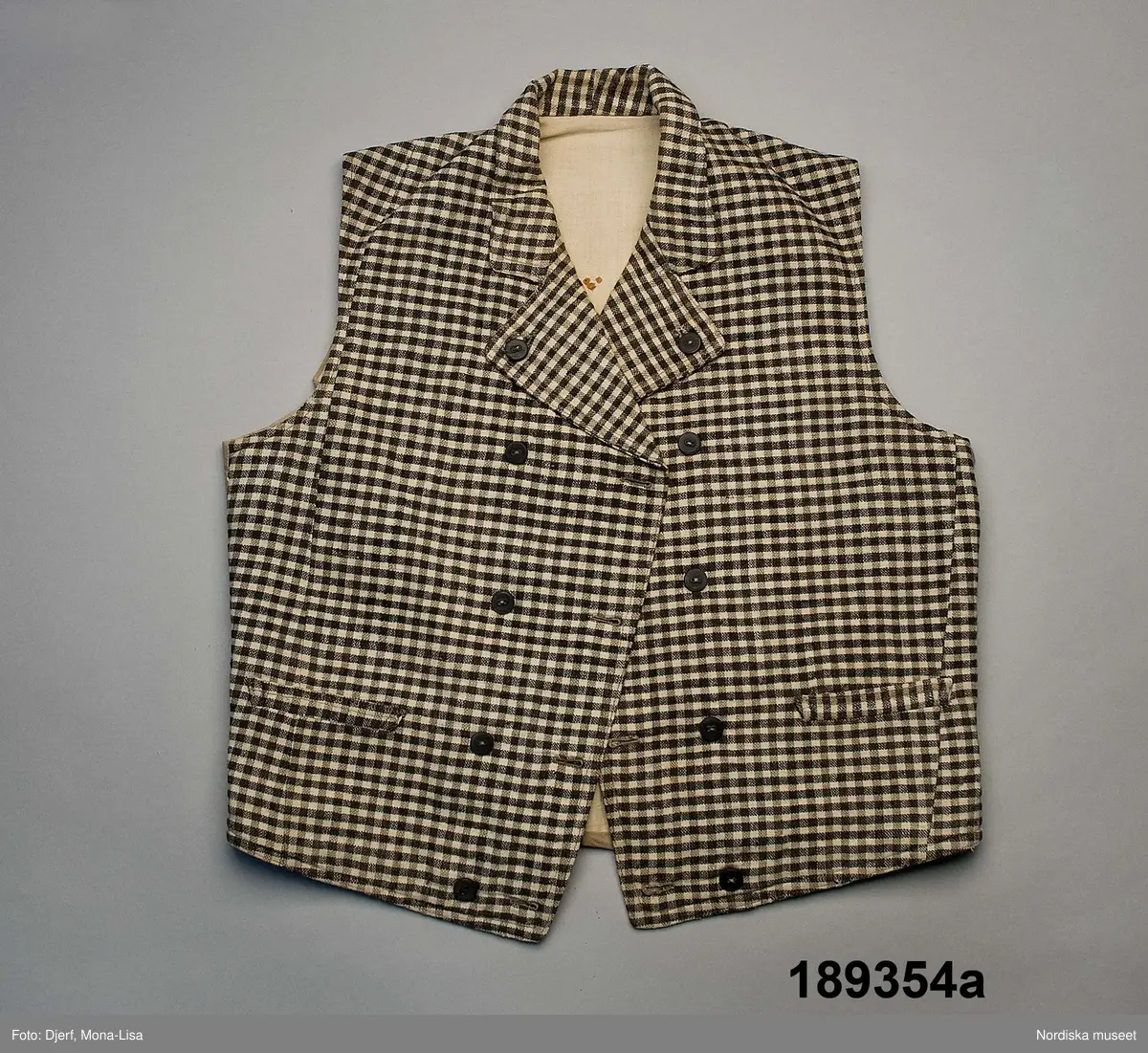 Huvudliggaren (år 1931-1932):
"189354 ab Väst m byxor, från Ösby, Lunda sn, Seminghundra hd, Upland, ylle, smårutigt i svart, grått och vitt; hemspunnet garn och hemvävt tyg, omkr 1860; säljarens svärfaders fästmanskläder; fr. fru Anna Karlsson, Ösby. 25:-"