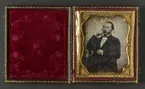 Porträtt av okänd man. Sittande, iklädd svart jacka, vit skjorta och svart halsduk. Glasögon och skägg. Dagerrotyp / daguerreotyp i sidenfodrat etui av amerikansk typ, ca 1850. Nordiska museet inv.nr 230443.
-
Portrait of an unidentified man, c. 1850. Sixth-plate daguerreotype in velvet lined case with gilt decorations.