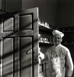 Köksmästare Paul Arbin vid dörr med texten "H. M. KONUNGENS 