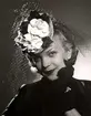 Hattmode, Nordiska Kompaniet 1941. Kvinnlig modell iförd liten rund hatt med flor och blomsterdekoration.