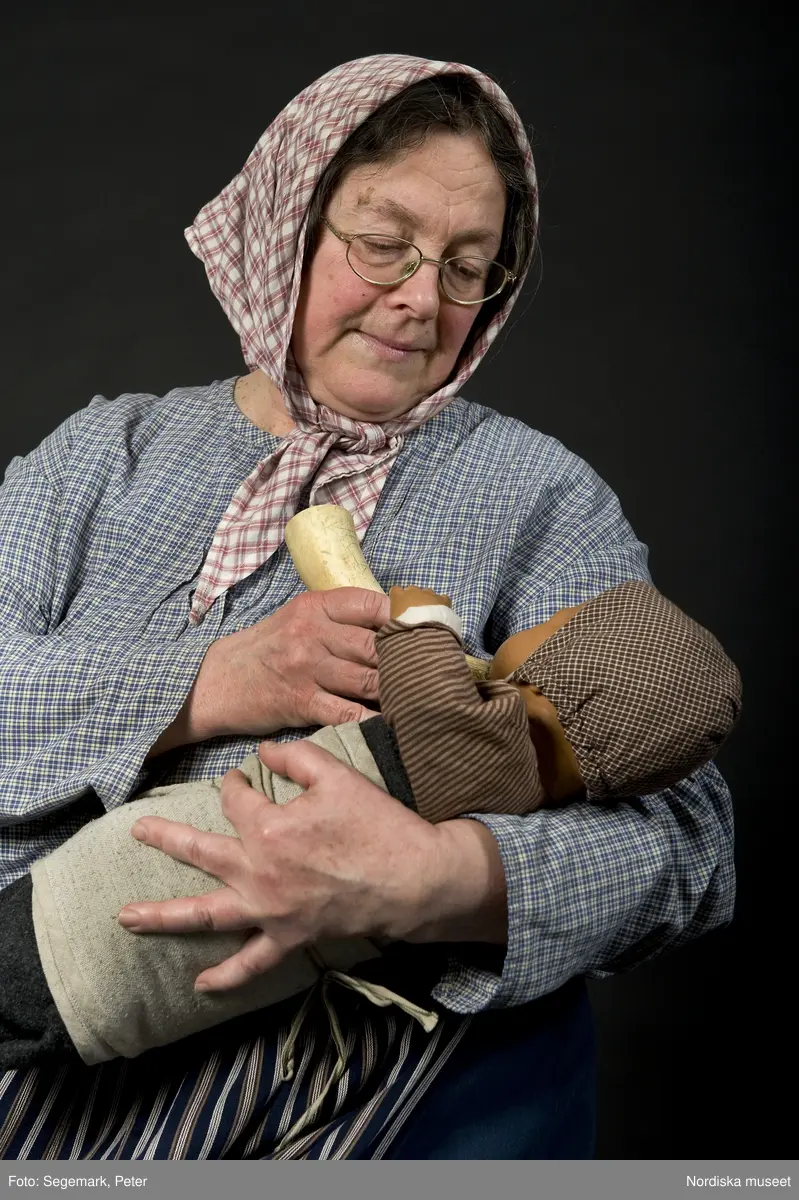Pedagoger vid Nordiska museet 2010. Museipedagogen Kerstin Cunelius som "mor i stugan". Fotodokumentation av pedagogerna i museets Lekstuga med kläder och rekvisita.