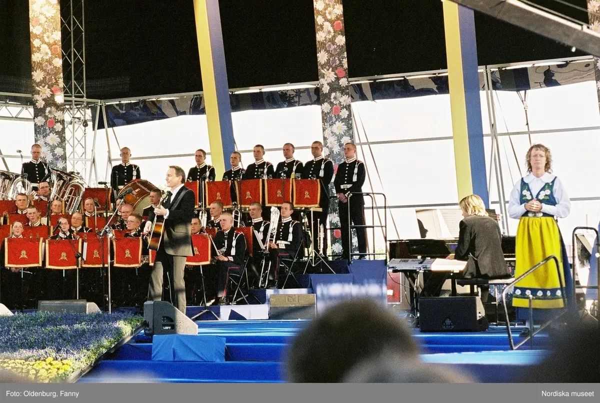 Firandet av den svenska nationaldagen den 6 juni 2004 på Skansen, Stockholm. Den kungliga familjen. Orkester. Publik. Artisterna Shirley Clamp, Tomas Ledin och Lasse Berghagen. Programledaren Agneta Bolme Börjefors.