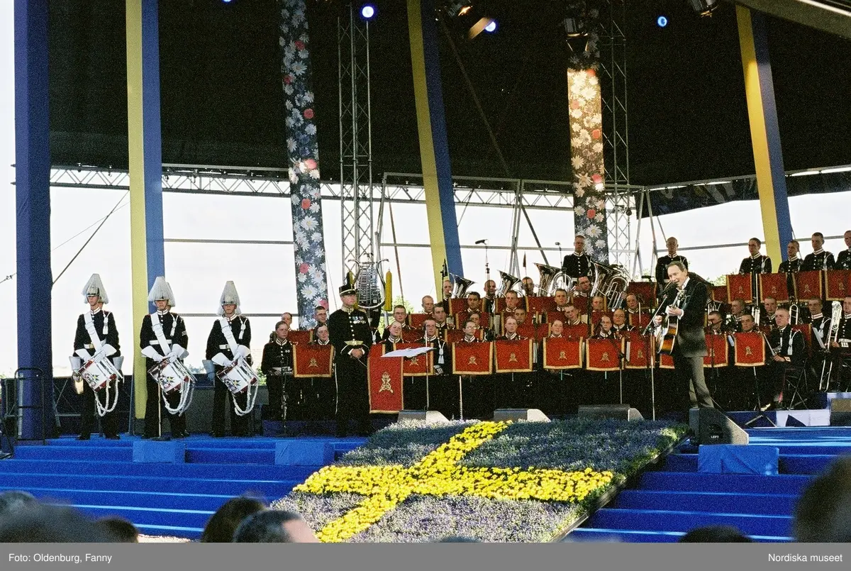 Firandet av den svenska nationaldagen den 6 juni 2004 på Skansen, Stockholm. Den kungliga familjen. Orkester. Publik. Artisterna Shirley Clamp, Tomas Ledin och Lasse Berghagen. Programledaren Agneta Bolme Börjefors.