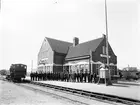 Trelleborg F med personal och växellok litt Ke nr 721 . Vy mot norr. I samband med färjetrafikens början uppfördes en station i anslutning till färjelägena, Trelleborg F. Stationen togs i bruk i december 1907. Första våningen inrymde väntsal, expedition och biljetförsäljning, andra våningen övernattningsrum för personal. Källa: I Kindahl, Den gamla goda tiden .