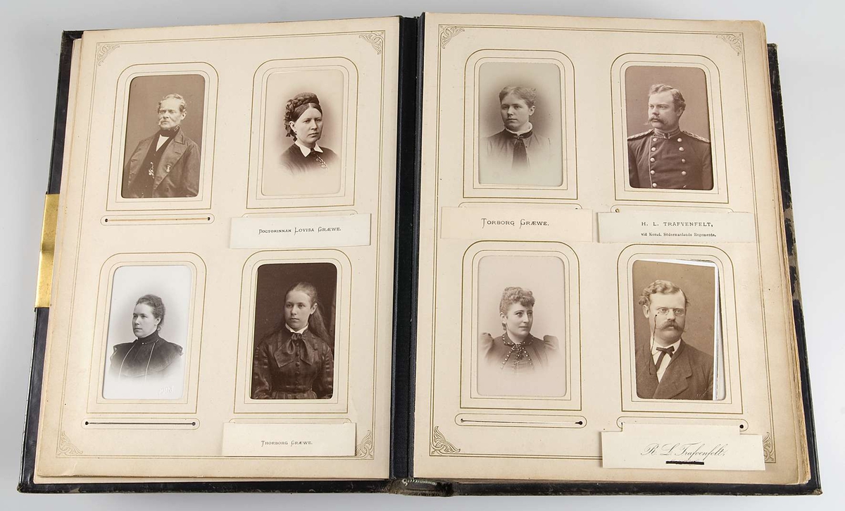 Fotoalbum med pärmar av svart läder och dekor i relief och guldtryck. På framsidans pärm finns en mittspegel av glas på vilket ett landskapsmotiv i månsken är målat. På baksidans pärm finns fyra nitar av metall.