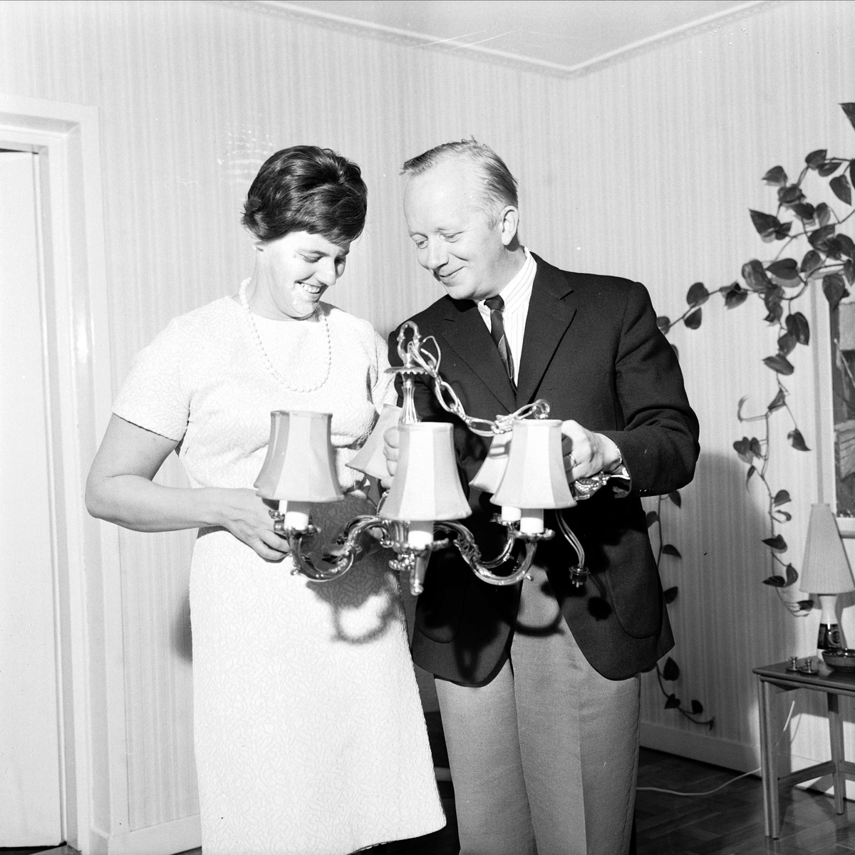 Kyrkoadjunkt Jean Johansson med maka håller i taklampa, Tierp, Uppland 1967