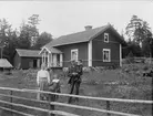 Kvinna, man och två barn framför bostadshus