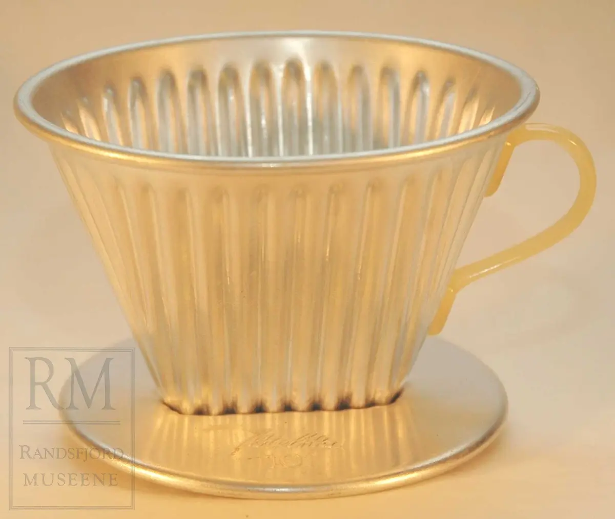 Aluminium med plasthank. Til å sette på kaffekanne. Riflet gods.