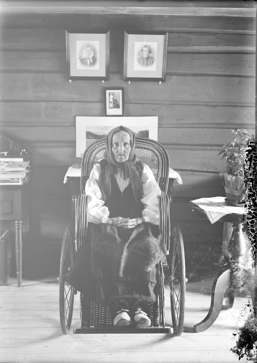 Eldre kvinne fra Otta i damaskstakk sittende i rullestol. Gunnar Kleivmellom's mor