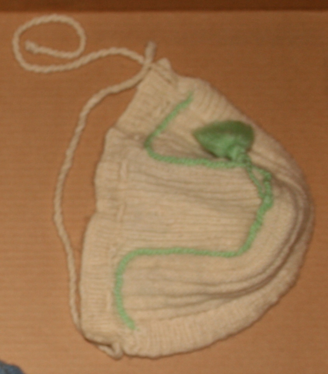 Strikka ullhue m. bomullsfor
Tvinna grøn smor og dusk påsydd til pynt