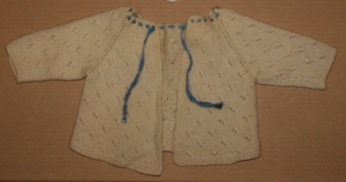 Strikka ulljakke.
Glattstrikk m. hullmønster
perlestrikk - kantar
raglanfelling
blå knytesnor i hals - silke