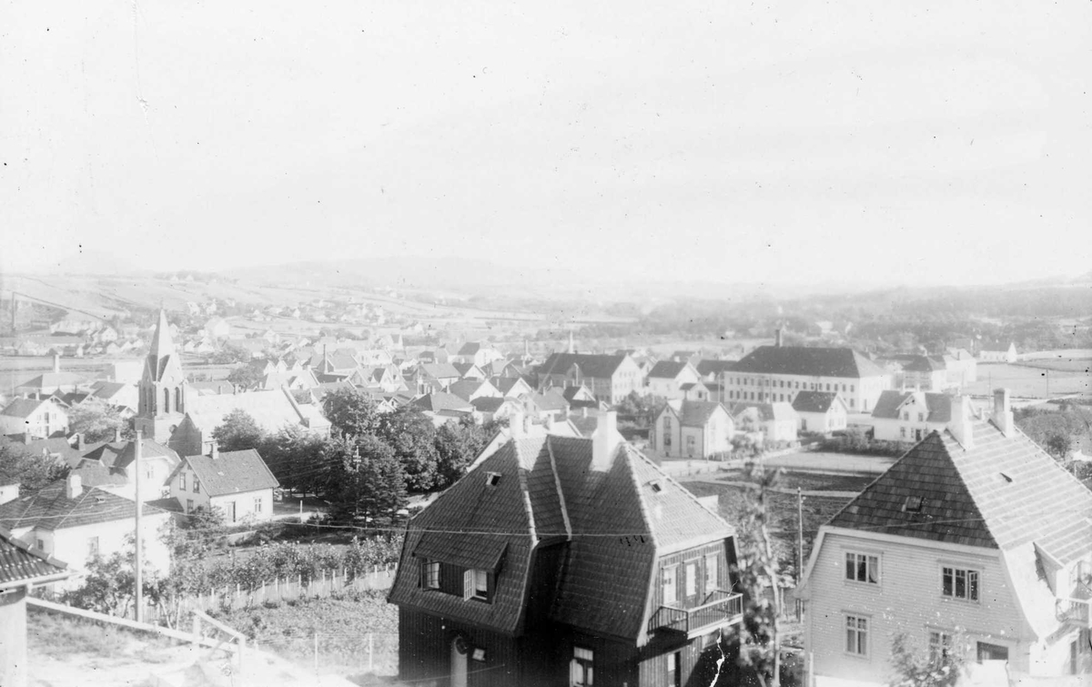 Sandnes sentrum sett fra nord-vest. Huset (Falsensgate 32, idag Kirkegate 21a) t.h. ble bygd i 1920 til lensmann Herman Pedersen, huset t.v.(idag Kirkegate 21b) tilhørte Jon Davies, som jobbet for Sandnes Uldvarefabrikk.