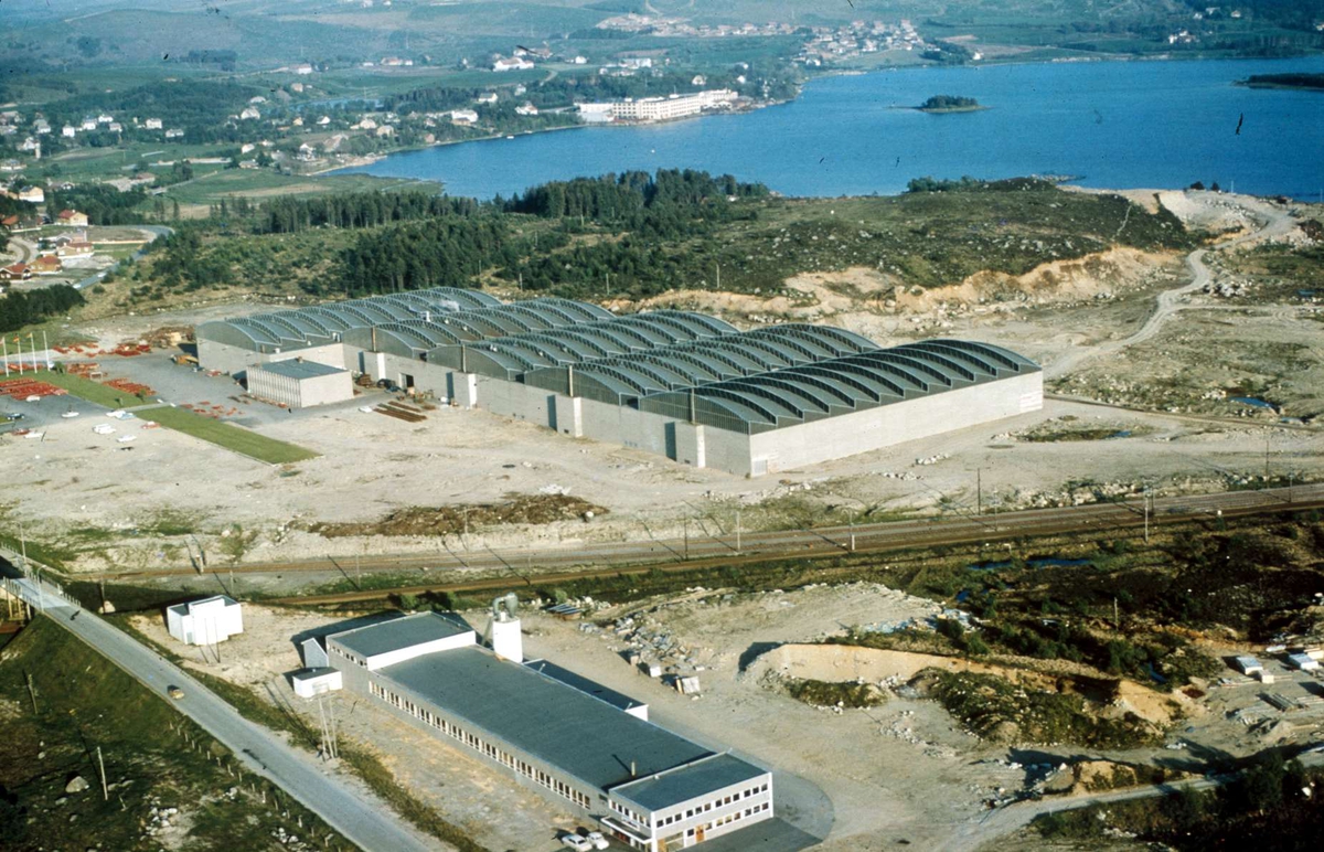 Flyfotografi av Øksnevadanlegget til Kverneland fabrikk med Frøylandsvatnet og den gamle fabrikken i bakgrunnen