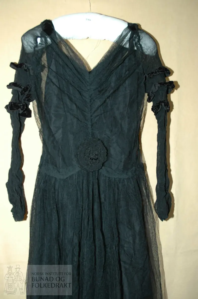 Grand galla kjole fra 1900, samt underkjole og bolero. 

Materiale: "Silketaft", truleg kunststoff, svart tyll, fløyelsband- Trykknappar i sidene. 