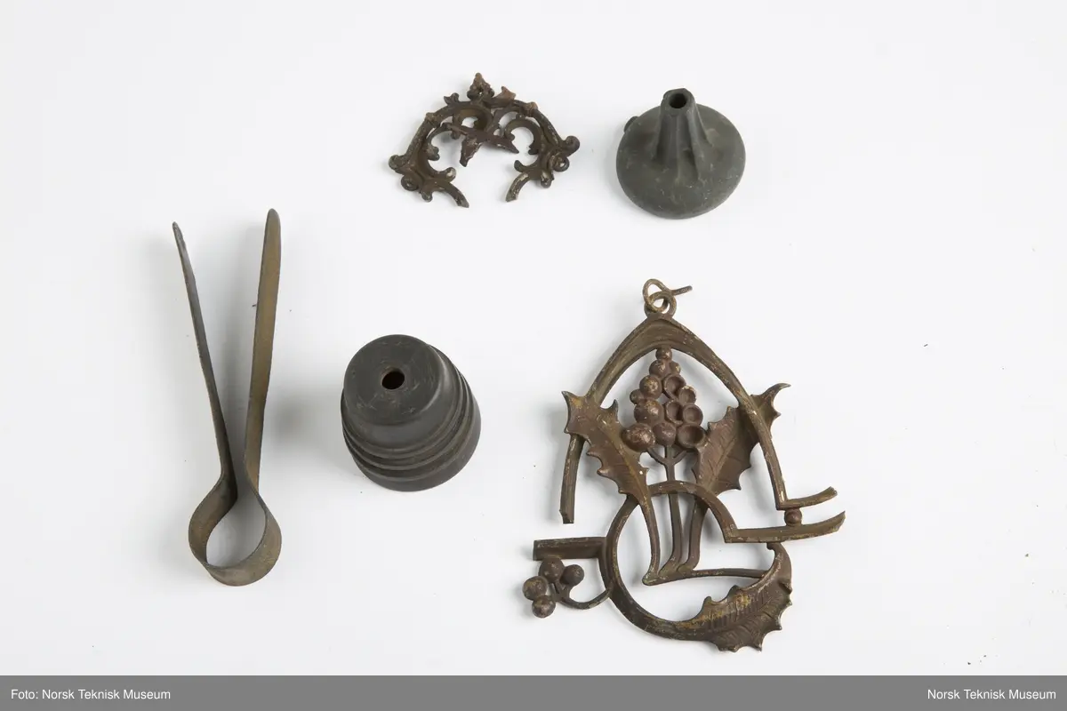 Lysekrone / hengelampe i metall for sju lys (seks lys + ett i midten). Lampa er ødelagt og i mange deler, oppheng, løse pæreholdere, glassbeholder, kuppel etc.