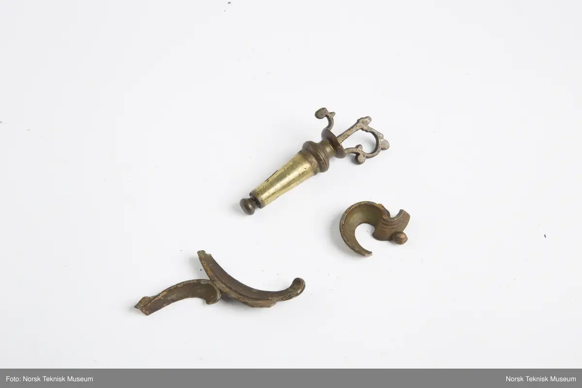 Lysekrone / hengelampe i metall for sju lys (seks lys + ett i midten). Lampa er ødelagt og i mange deler, oppheng, løse pæreholdere, glassbeholder, kuppel etc.